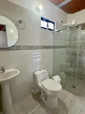 a bathroom with a toilet and a sink and a shower at Entre Cafetales in Jardin