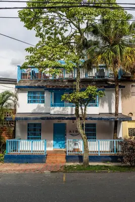 a blue and white building with a tree in front of it at Casa en Poblado para grupos in Medellín