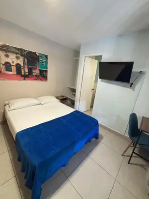 a bedroom with a bed with a blue blanket at Casa en Poblado para grupos in Medellín