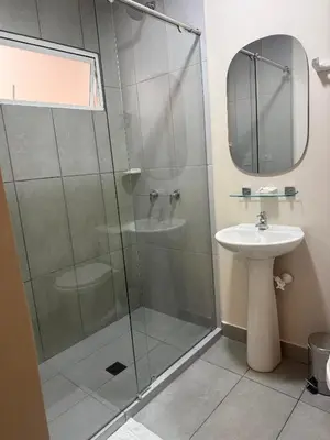 a bathroom with a glass shower and a sink at Casa en Poblado para grupos in Medellín