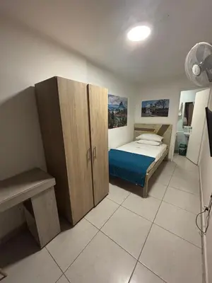 a bedroom with a bed and a wooden cabinet at Casa en Poblado para grupos in Medellín