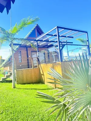 a house with a blue roof and a palm tree at Glamping en Rionegro in Rionegro