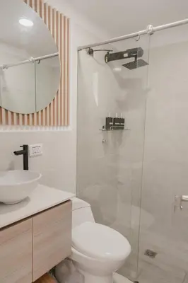 a bathroom with a toilet and a glass shower at Apartamento en Rionegro, Cerca al aeropuerto JMC in Rionegro