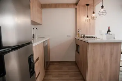 a kitchen with wooden cabinets and a stainless steel refrigerator at Apartamento en Rionegro, Cerca al aeropuerto JMC in Rionegro