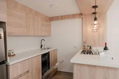a kitchen with a white counter top and wooden cabinets at Apartamento en Rionegro, Cerca al aeropuerto JMC in Rionegro