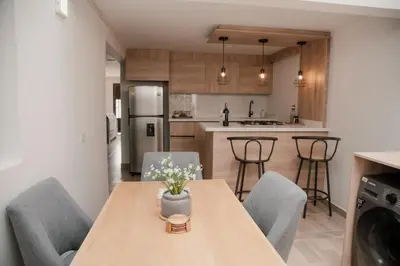 a kitchen and dining room with a wooden table and chairs at Apartamento en Rionegro, Cerca al aeropuerto JMC in Rionegro