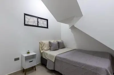 a small white bedroom with a bed and a window at Lujoso pent-house de dos niveles in Itagüí