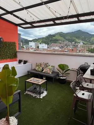 a patio with a couch and a table on a roof at Lujoso pent-house de dos niveles in Itagüí