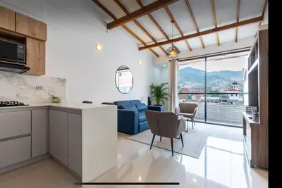 a kitchen and living room with a view at Lujoso pent-house de dos niveles in Itagüí
