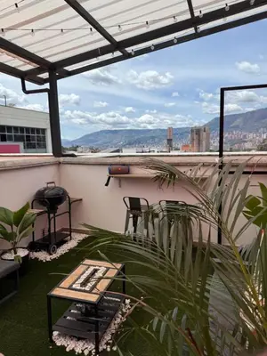 a patio with a table and chairs and a grill at Lujoso pent-house de dos niveles in Itagüí