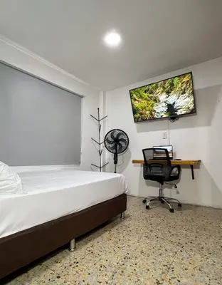 a bedroom with a bed and a desk and a chair at Apartamento en Belén San Bernardo, Medellín in Medellín