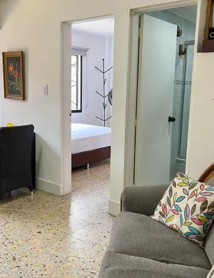 a living room with a couch and a bedroom at Apartamento en Belén San Bernardo, Medellín in Medellín