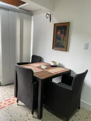 a dining room table with chairs in a room with a picture at Apartamento en Belén San Bernardo, Medellín in Medellín