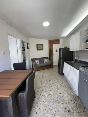 a kitchen and living room with a table and a couch at Apartamento en Belén San Bernardo, Medellín in Medellín