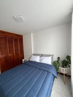 a bedroom with a blue bed and a plant at Hermosa habitación con excelente ubicación in Medellín