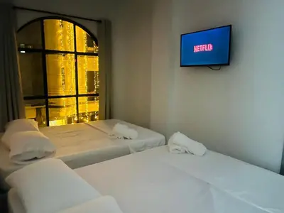 a room with two beds and a tv on the wall at Habitaciones en Doradal 204 in Doradal