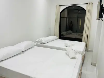 two beds sitting in a room with a mirror at Habitaciones en Doradal 204 in Doradal