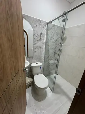 a bathroom with a toilet and a glass shower at Habitaciones en Doradal 204 in Doradal