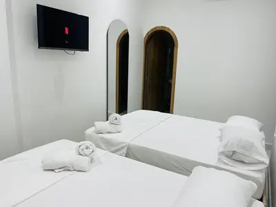 two beds in a room with a tv on the wall at Habitaciones en Doradal 204 in Doradal