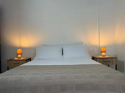 a bedroom with a bed with two lamps on two tables at Full apartment in Laureles in Medellín