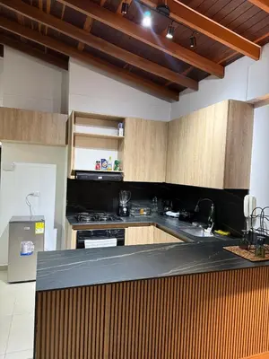 a kitchen with wooden cabinets and a black counter top at Full apartment in Laureles in Medellín
