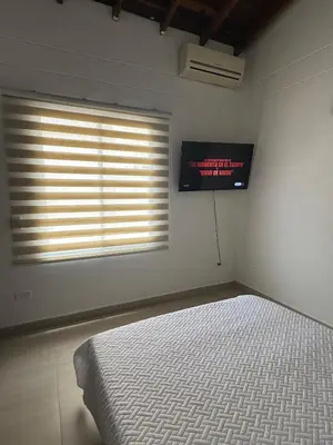 a bedroom with a bed and a television on the wall at Refugio en laureles in Medellín