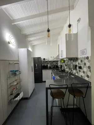 a kitchen with a sink and two chairs in it at Casa Florez in Medellín