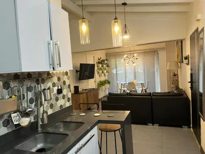 a kitchen with two sinks and a living room at Casa Florez in Medellín