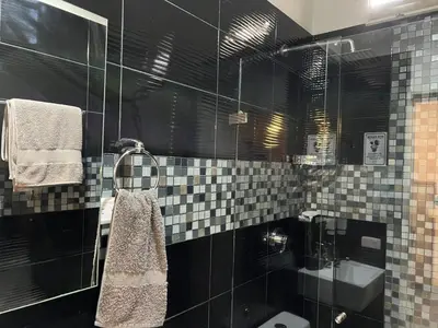 a bathroom with black and white tile walls and a sink at Casa Florez in Medellín
