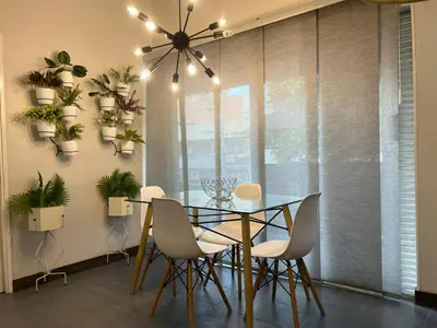a dining room with a glass table and chairs at Casa Florez in Medellín