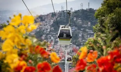 a gondola flying over a city with flowers at Apartamento balcón laureles estadio ED Milagros in Medellín