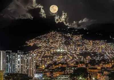 a view of a city at night with a full moon at Apartamento balcón laureles estadio ED Milagros in Medellín