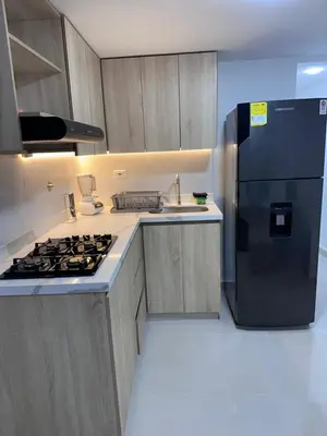 a kitchen with a black refrigerator and a sink at Apartamento laureles estadio 201 ED MILA in Medellín