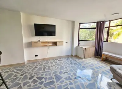 a living room with a flat screen tv on the wall at Exclusive Stadium Apartment in Medellín