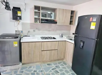 a kitchen with a black refrigerator and a sink at Exclusive Stadium Apartment in Medellín