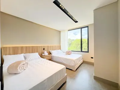 a bedroom with two beds and a large window at Apartamento de lujo a 3 minutos del Aeropuerto JMC 302 in Rionegro