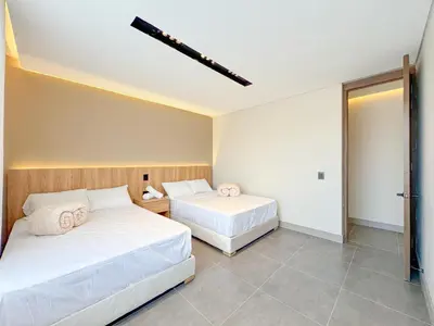 a bedroom with two beds and a door to another room at Apartamento de lujo a 3 minutos del Aeropuerto JMC 302 in Rionegro