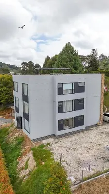 a white building on top of a field at Apartamento de lujo a 3 minutos del Aeropuerto JMC 302 in Rionegro