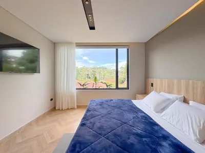 a bedroom with a large bed with a large window at Apartamento de lujo a 3 minutos del Aeropuerto JMC 302 in Rionegro