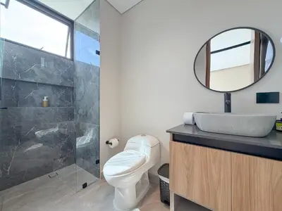 a bathroom with a toilet and a sink and a mirror at Apartamento de lujo a 3 minutos del Aeropuerto JMC 301 in Rionegro