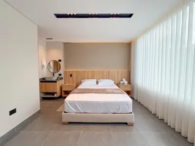 a bedroom with a bed and a large window at Apartamento de lujo a 3 minutos del Aeropuerto JMC 202 in Rionegro