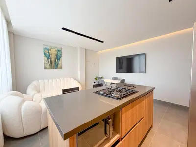 a kitchen with a counter top and a living room at Apartamento de lujo a 3 minutos del Aeropuerto JMC 202 in Rionegro