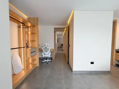 a hallway with a white wall and a chair in a room at Apartamento de lujo a 3 minutos del Aeropuerto JMC 202 in Rionegro
