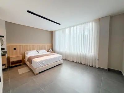 a bedroom with a bed and a large window at Apartamento de lujo a 3 minutos del Aeropuerto JMC 202 in Rionegro