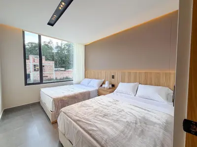 a bedroom with two beds and a window at Apartamento de lujo a 3 minutos del Aeropuerto JMC 202 in Rionegro