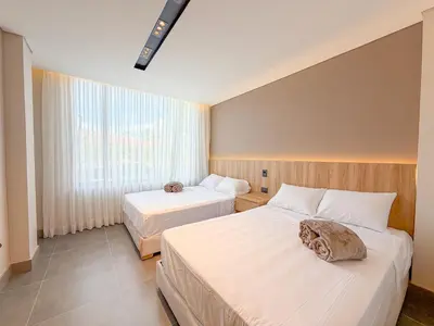 a hotel room with two beds and a window at Apartamento de lujo a 3 minutos del Aeropuerto JMC 202 in Rionegro