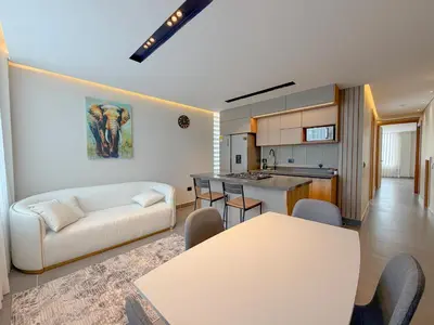 a living room with a white couch and a kitchen at Apartamento de lujo a 3 minutos del Aeropuerto JMC 201 in Rionegro