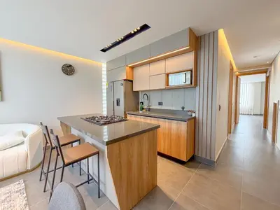 a kitchen and living room with a counter and chairs at Apartamento de lujo a 3 minutos del Aeropuerto JMC 201 in Rionegro