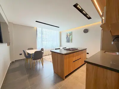 a kitchen with a counter and a table with chairs at Apartamento de lujo a 3 minutos del Aeropuerto JMC 201 in Rionegro