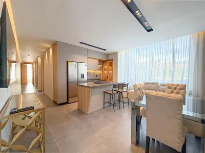 a kitchen and a living room with a table and chairs at Apartamento de lujo a 3 minutos del Aeropuerto JMC 102 in Rionegro